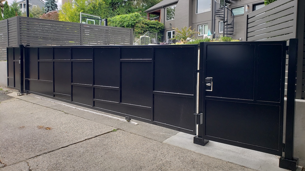Black panel sliding driveway gate with matching pedestrian walk gate