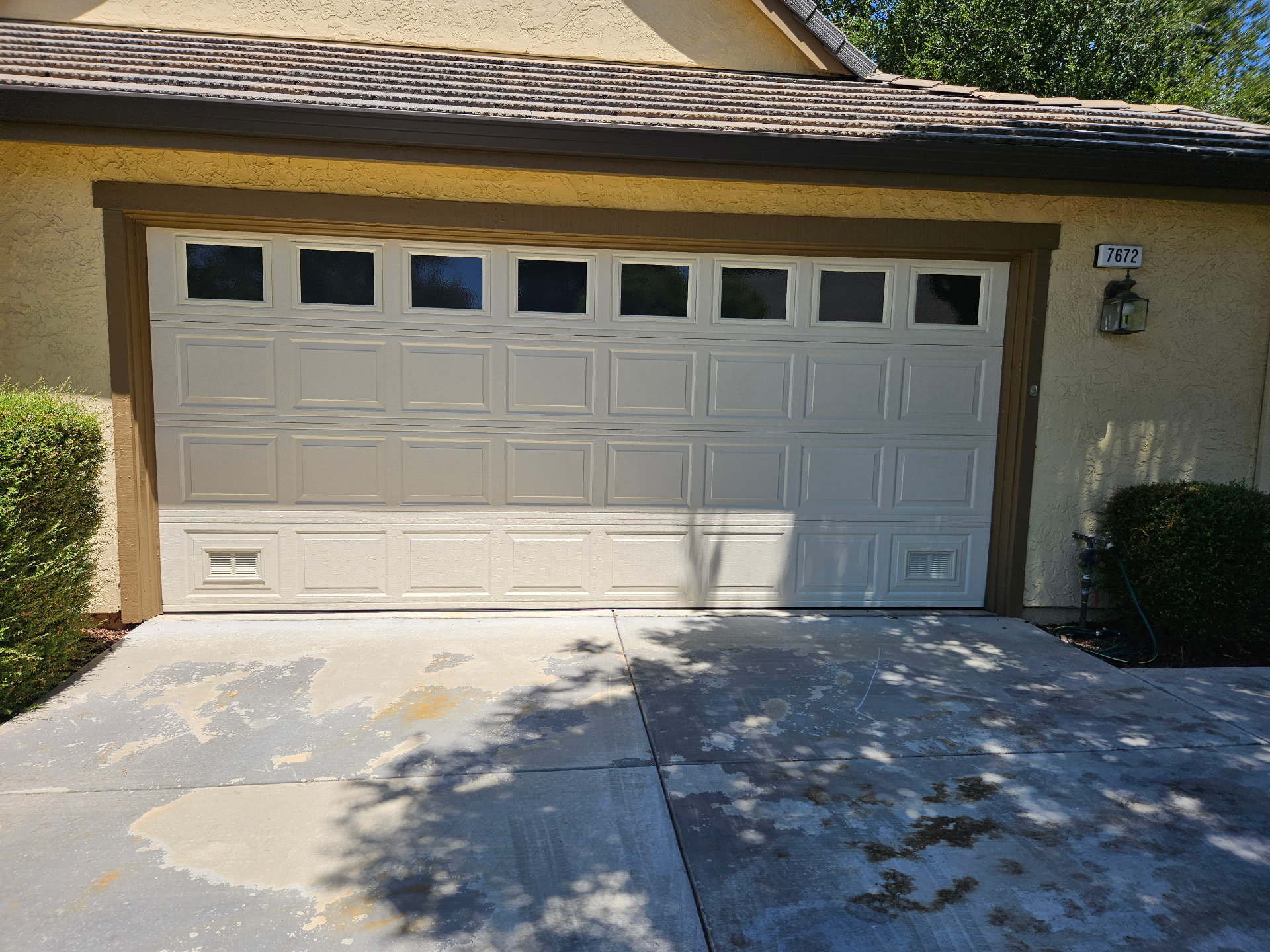 Residential raised-panel garage door with windows installed in Marin County