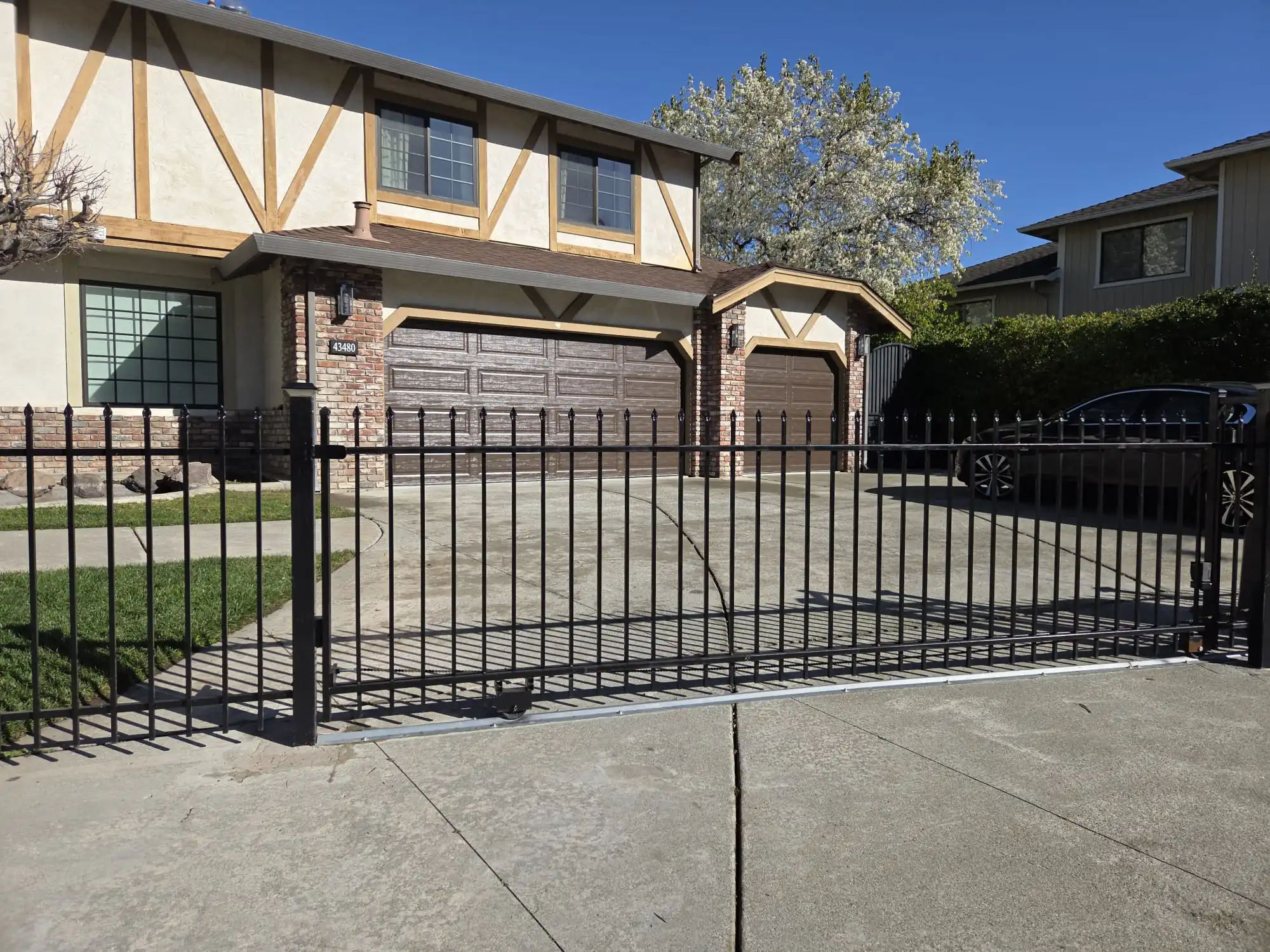 Black ornamental iron automatic driveway gate installed by Al's Automatic Gate