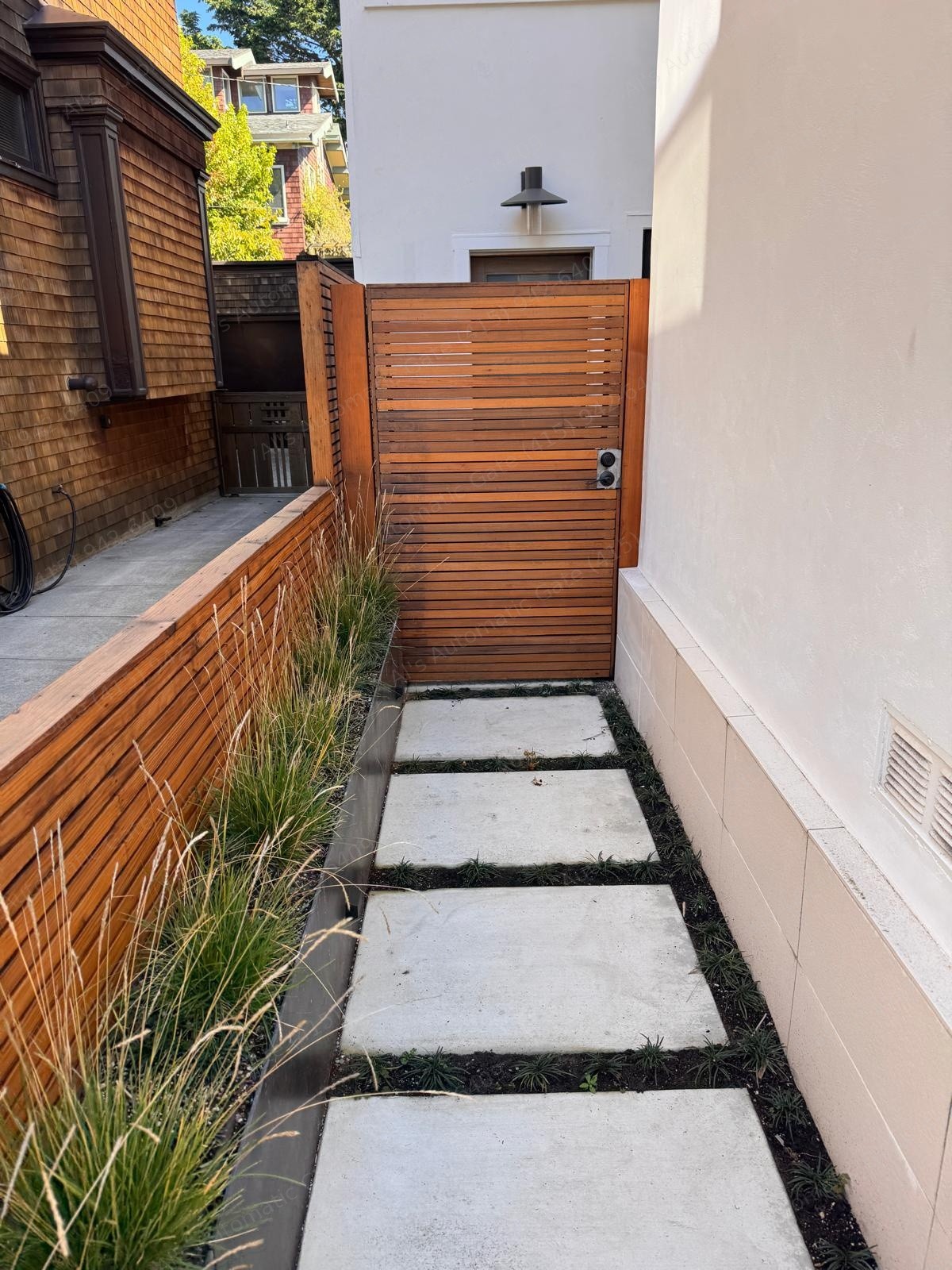 Redwood slat side-yard gate over a paver path